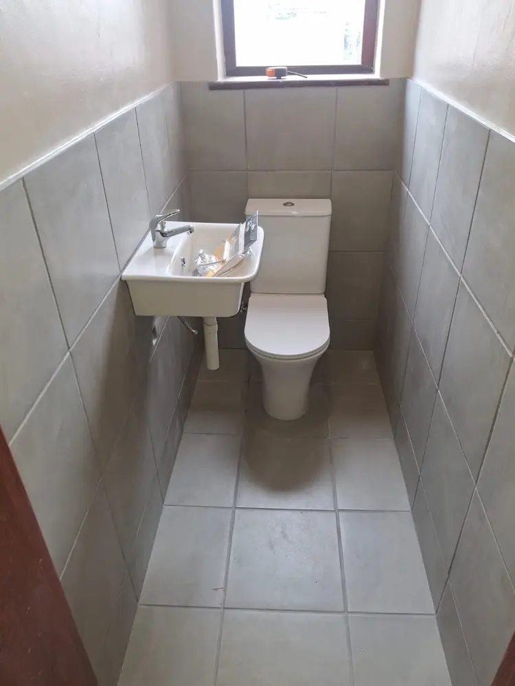 New guest toilet with a wall-hung basin, close-coupled WC and full tiling