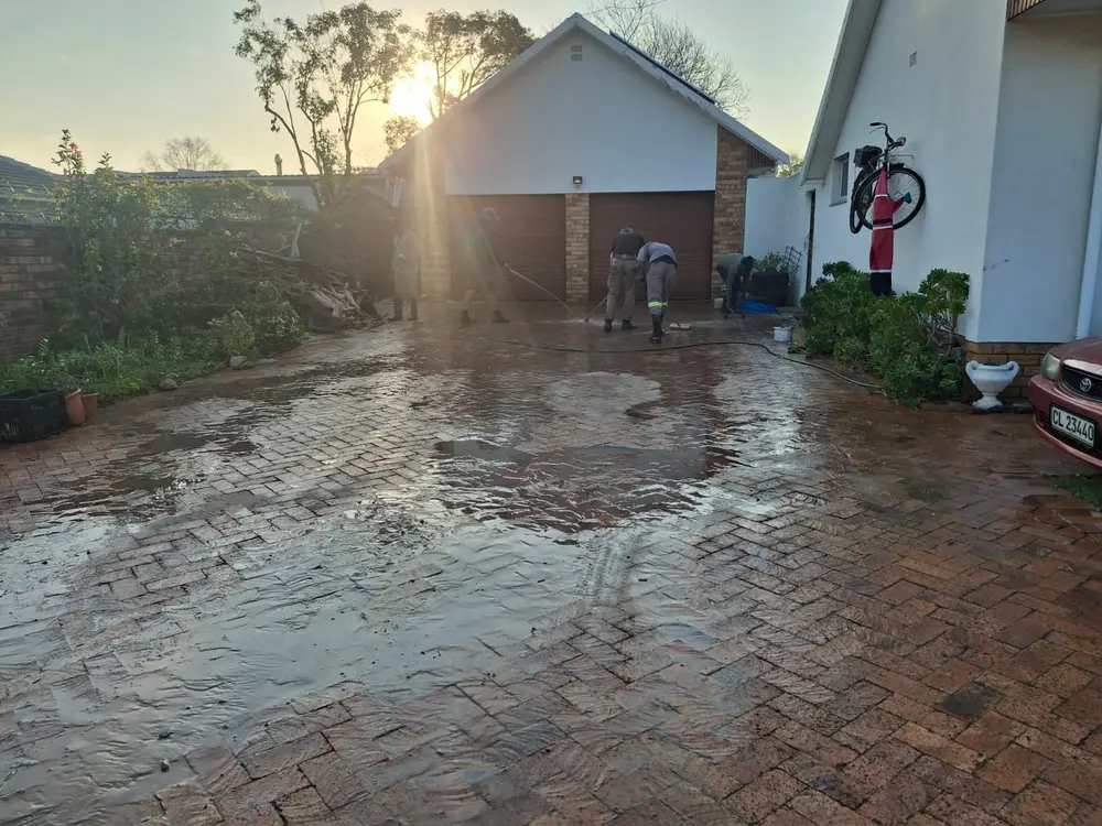Washing down a client's brick driveway after finishing the job