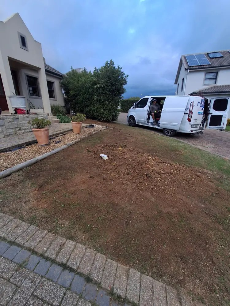 A Vic's Plumbing service van on site, with the garden reinstated after a pipe replacement